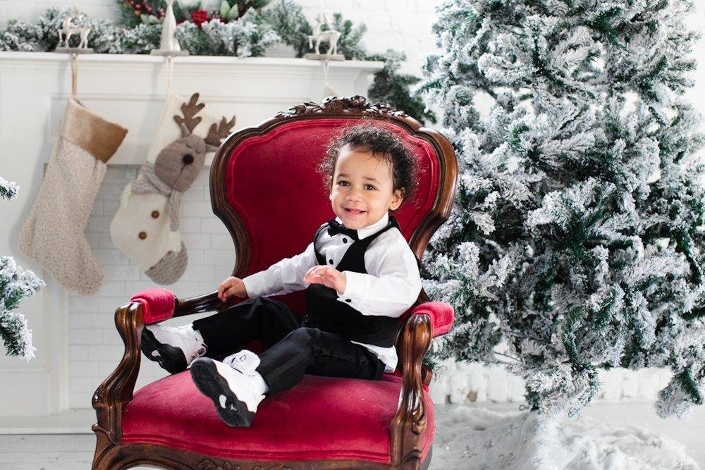 child sitting in red antique chair - Christmas photoshoot